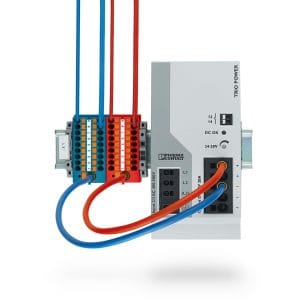 Een blauw en rood voedingsverdeelblok van Phoenix Contact gemonteerd op een DIN-rail.